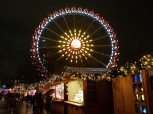 Buden auf dem Weihnachtsmarkt am Roten Rathaus und Blick auf das Riesenrad dahinter