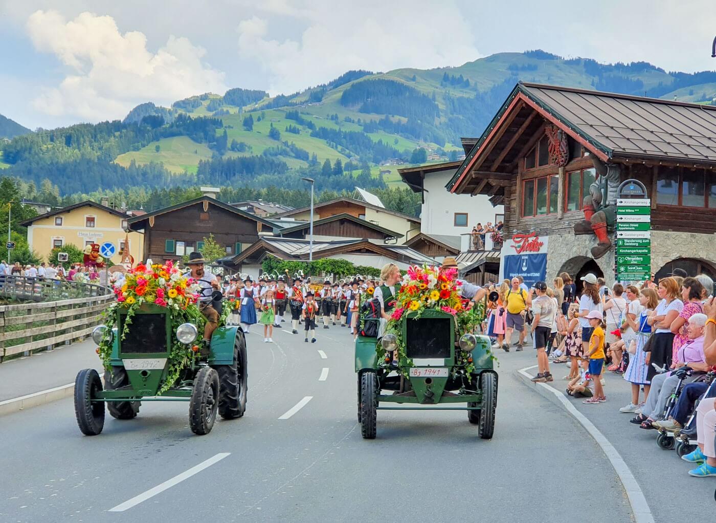 zwei blumengeschmückte Traktoren beim blumencorso mit dem Gaisberg im Hintergrund