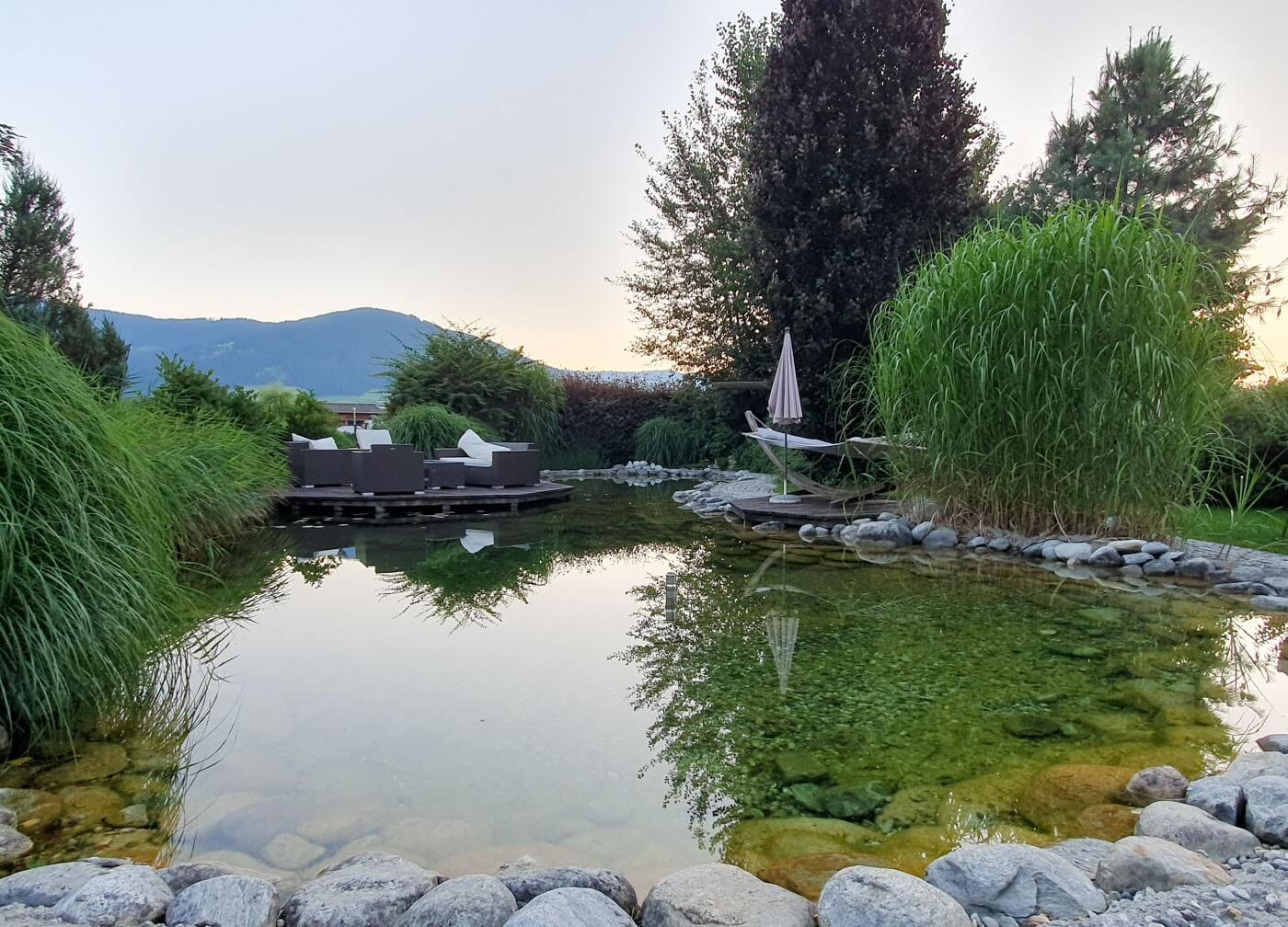 Gartenteich im Landhotel Schermer mit Sitzgruppe im Hintergrund