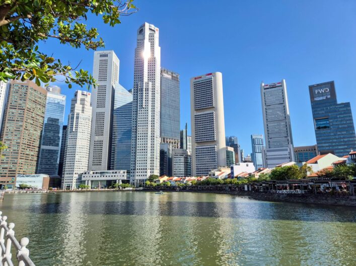 silbern in der Sonne glitzernde Hochhäuser am Singapore River